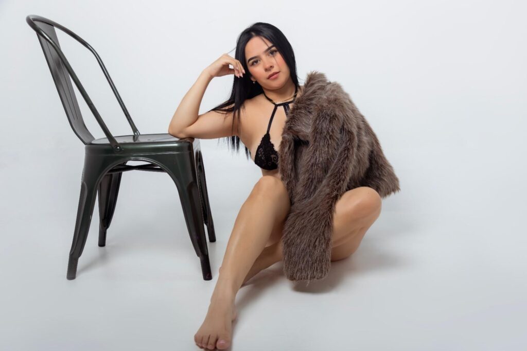 MiaAylen relaxing with the elbow on a chair and a fur coat covering her sexy body